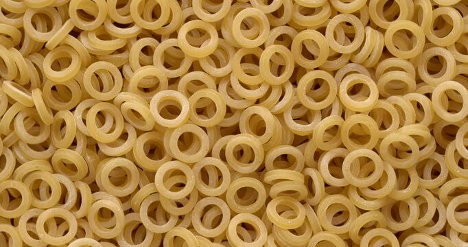 Sicilian rings dry pasta background texture - small, thin rings used for soups and cold pasta salads. Zoom in while rotating.