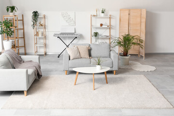Interior of light living room with shelving unit, sofas and coffee table
