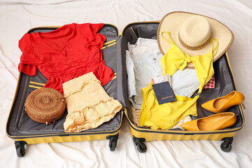 Open suitcase with belongings on white background. Travel concept