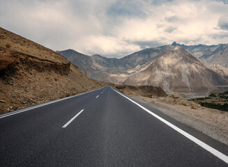 A long, empty road with a mountain range in the background