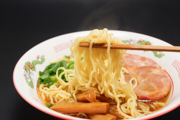 Trying to eat warm soy sauce ramen with chopsticks.