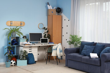 Interior of teenager's room with workplace and sofa