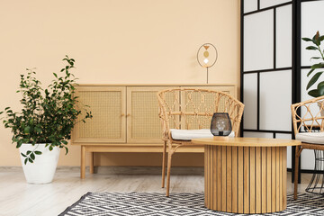 Interior of stylish living room with folding screen, drawers and table