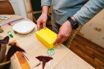A man wraps a gift for his wife on Valentine's Day.