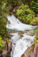 Beautiful mountain waterfall in the forest. Mountain landscape with a waterfall.
