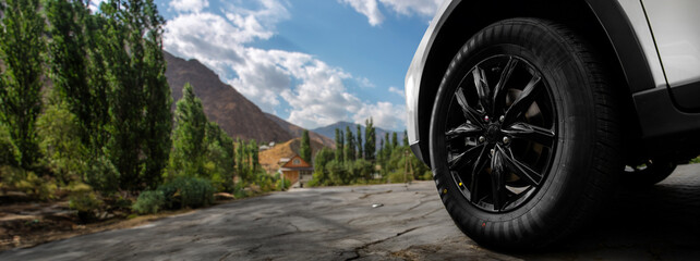 A black tire on a road with a mountain in the background