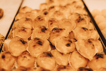 Close-Up fresh Pastel de Nata in the window of a bakery in Lisbon, Portugal. Solo tourism and travel