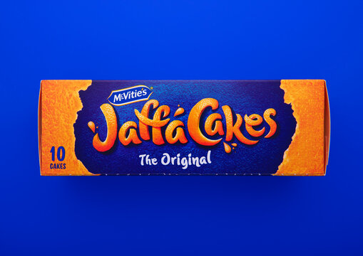 LONDON, UK - JANUARY 31, 2025: Box of Jaffa Cakes biscuits filled with orange marmalade and topped with milk chocolate on blue background.