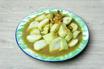 Soto daging (Indonesian meat soup) with lontong (rice cake) in indoneisan plate