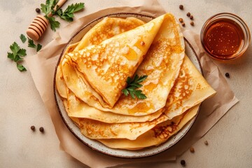 Delicious golden crepes arranged artfully on a rustic plate with honey and fresh herbs beside them