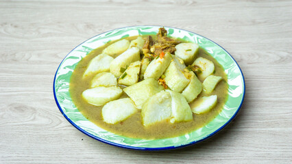 Soto daging (Indonesian meat soup) with lontong (rice cake) in indoneisan plate