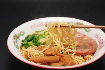 Trying to eat warm soy sauce ramen with chopsticks.