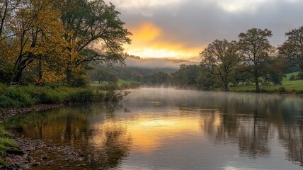 Obraz premium Peaceful river flowing soft ripples concept. A serene river at sunrise, surrounded by trees and mist, reflecting warm colors on the water.
