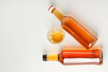 Bottles and glass of rum on white background