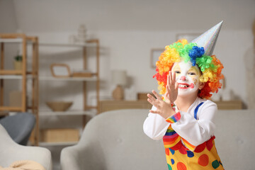 Little girl in clown costume grimacing at home. April Fools' Day celebration