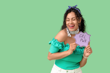Young African-American pin-up woman with GRL PWR sign on green background. Women's History Month