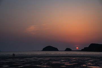 갯벌에 지는 붉은 태양의 노을과 커플