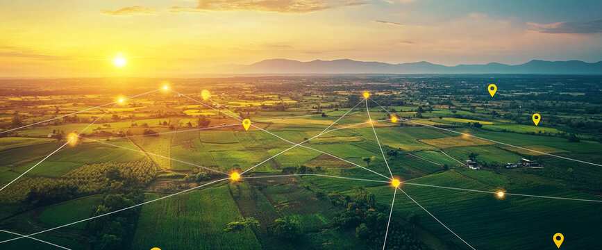 Aerial view of farmland at sunset with digital connections represented by glowing location markers, symbolizing modern connectivity in agriculture and technology.