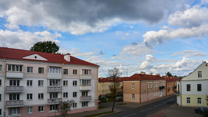 Summer urban landscape aerial view. Empty roads without people or cars. Cozy old apartment buildings against the background of clouds.