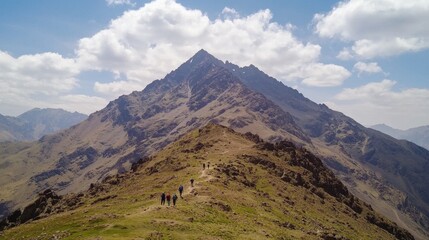 Fototapeta premium Hikers Explore Rugged Mountain Trail Under Sunny Blue Sky
