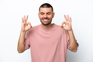 Naklejka premium Young caucasian man isolated on white background in zen pose