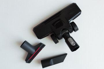Set of black plastic brushes and nozzles for vacuum cleaner. White background.