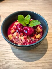Yogurt with berries, sweet dessert serving in restaurant. Korean dessert with raspberries, crunchy cookies and mint 