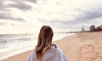 Obraz premium Woman walking on the promenade from behind.