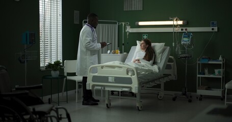 Doctor enters the room with a tablet, ready to review the patient's progress.