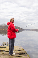 Fishing on the lake. Woman catches fish with a fishing rod