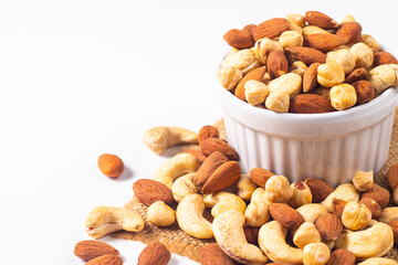 Large assortment of nuts in different bowls on stone table.