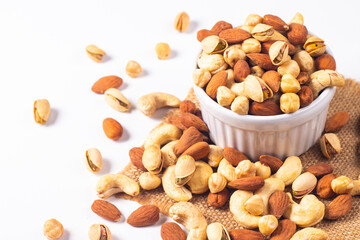 Large assortment of nuts in different bowls on stone table.