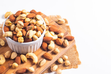 Large assortment of nuts in different bowls on stone table.