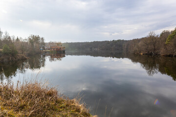 River in the forest. Reflection of trees in the water. Lake in the forest in winter