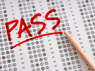 The word Pass written on a sheet of test exam paper with pencil.