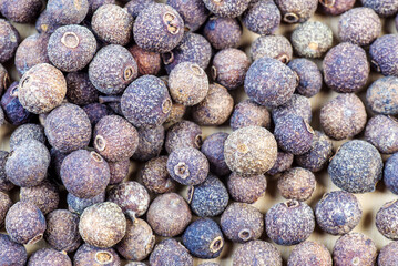 Freshly harvested allspice berries arranged on a surface showcasing their rich color and texture
