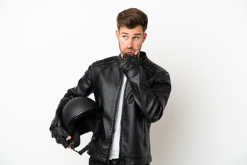 Fototapeta premium Young caucasian man with a motorcycle helmet isolated on white background having doubts and thinking