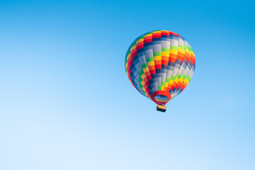 Colorful hot air balloon against the blue sky at sunny day.