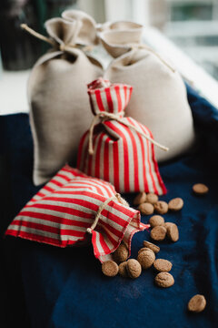 Little, decorative burlap sacks in a windowsill. One sack spilled baked goods