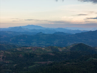 Naklejka premium Scenic view of rolling mountains at sunset highlighting beauty of nature