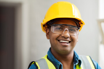 Portrait, happy or construction engineer in renovation site with glasses, hard hat or safety vest gear. Smile, Indian man or building contractor in property development or infrastructure inspection