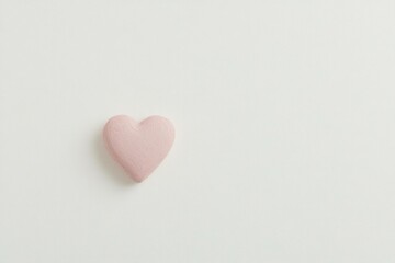 Fototapeta premium A soft pink heart on a minimalistic white background, symbolizing love and affection, perfect for romantic themes or emotional concepts