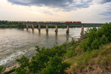 Obraz premium A train is crossing a bridge over a river