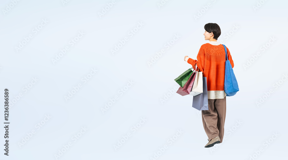 Aufkleber ショッピングバッグを持って歩くおしゃれなミドル女性の後ろ姿の全身写真