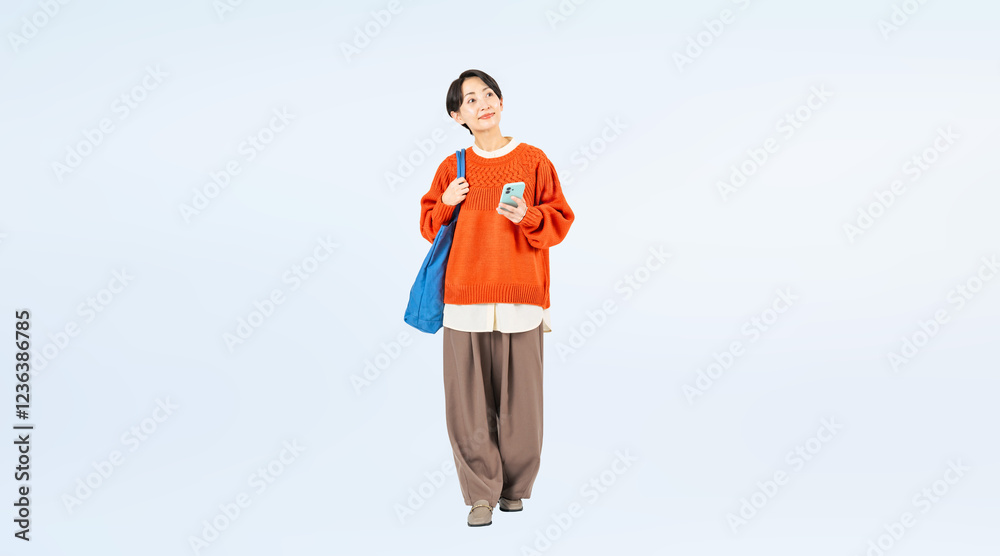 Aufkleber スマホを持って歩くおしゃれなミドル女性の全身写真
