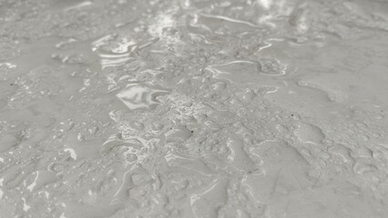 Water droplets spread across light gray textured surface.