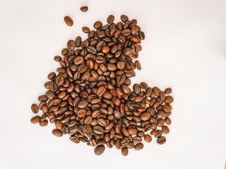 Coffee bean business. Coffee beans arranged in the shape of a heart on a white background. Coffee beans in a cafe.