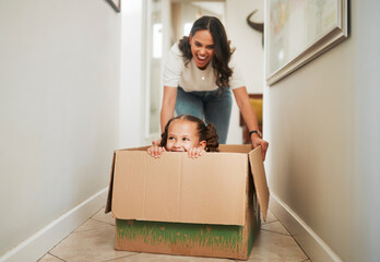 Mother, daughter and playing in box in new home for mortgage celebration, real estate success and...