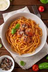 Traditional Italian spaghetti pasta with meatballs, tomato sauce and parmesan cheese, selective focus. Comfort food.