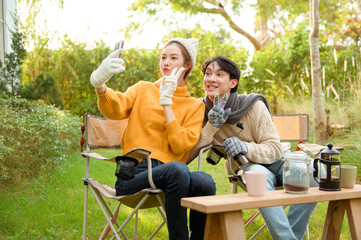 Fototapeta premium Two Friends Enjoying a Cozy Outdoor Moment While Taking a Selfie in a Sunny Garden
